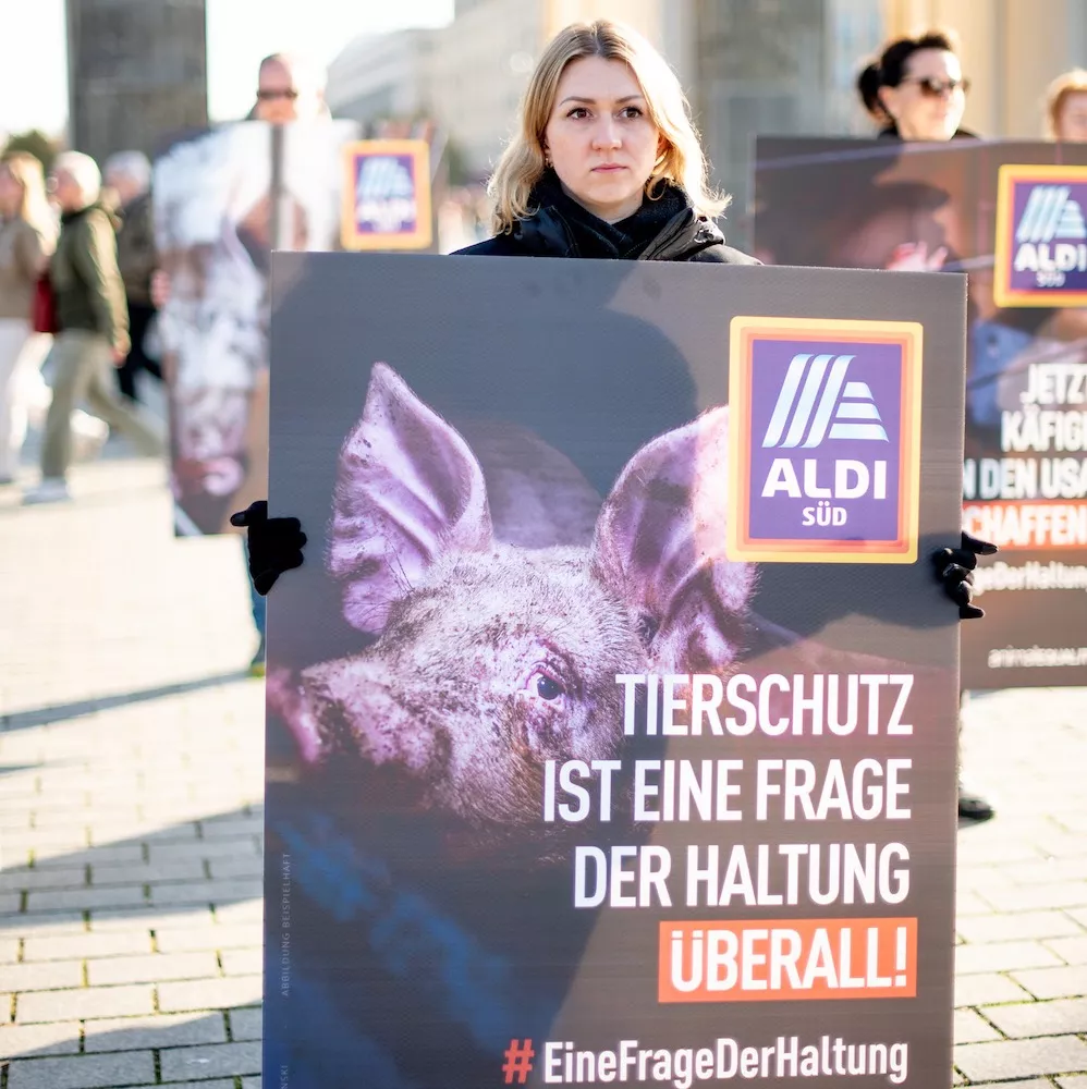 Voluntaria de Igualdad Animal con cartel de ALDI en protesta