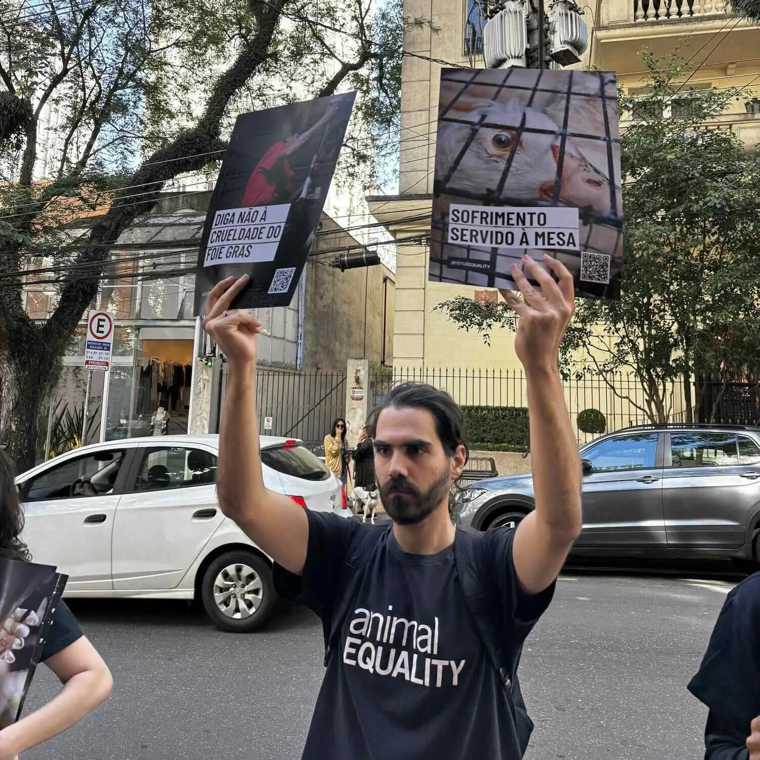 Joven con posters pidiendo el fin del foie gras durante protesta en Brasil